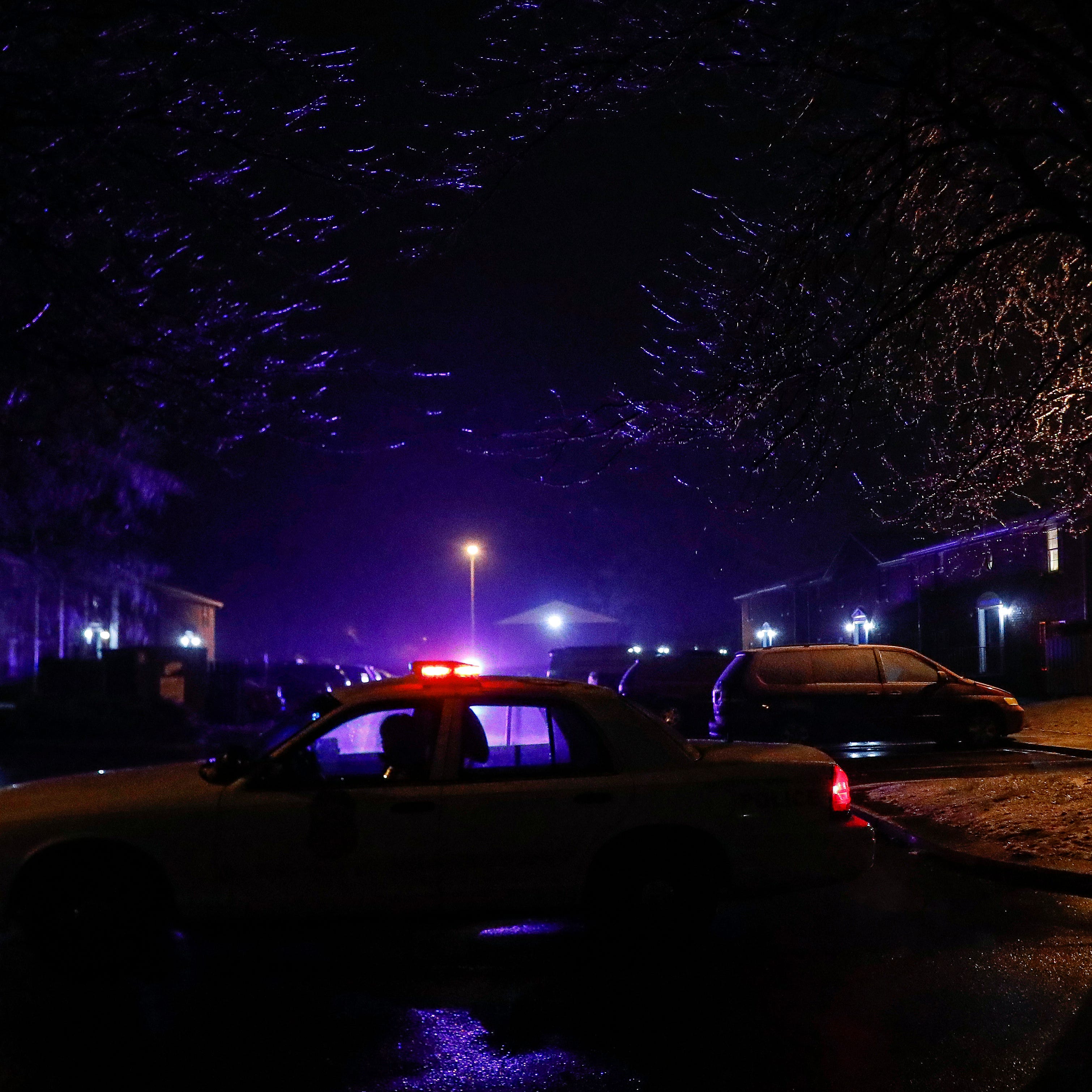 An officer blocks the end of a street of the apartment complex where four people, one woman and three men, were found dead in the 4100 block of Shady Oak Dr., Indianapolis, Wednesday, Feb. 5, 2020. The Indianapolis Metropolitan Police Department responded to a call for gunshots at 10:25 p.m.