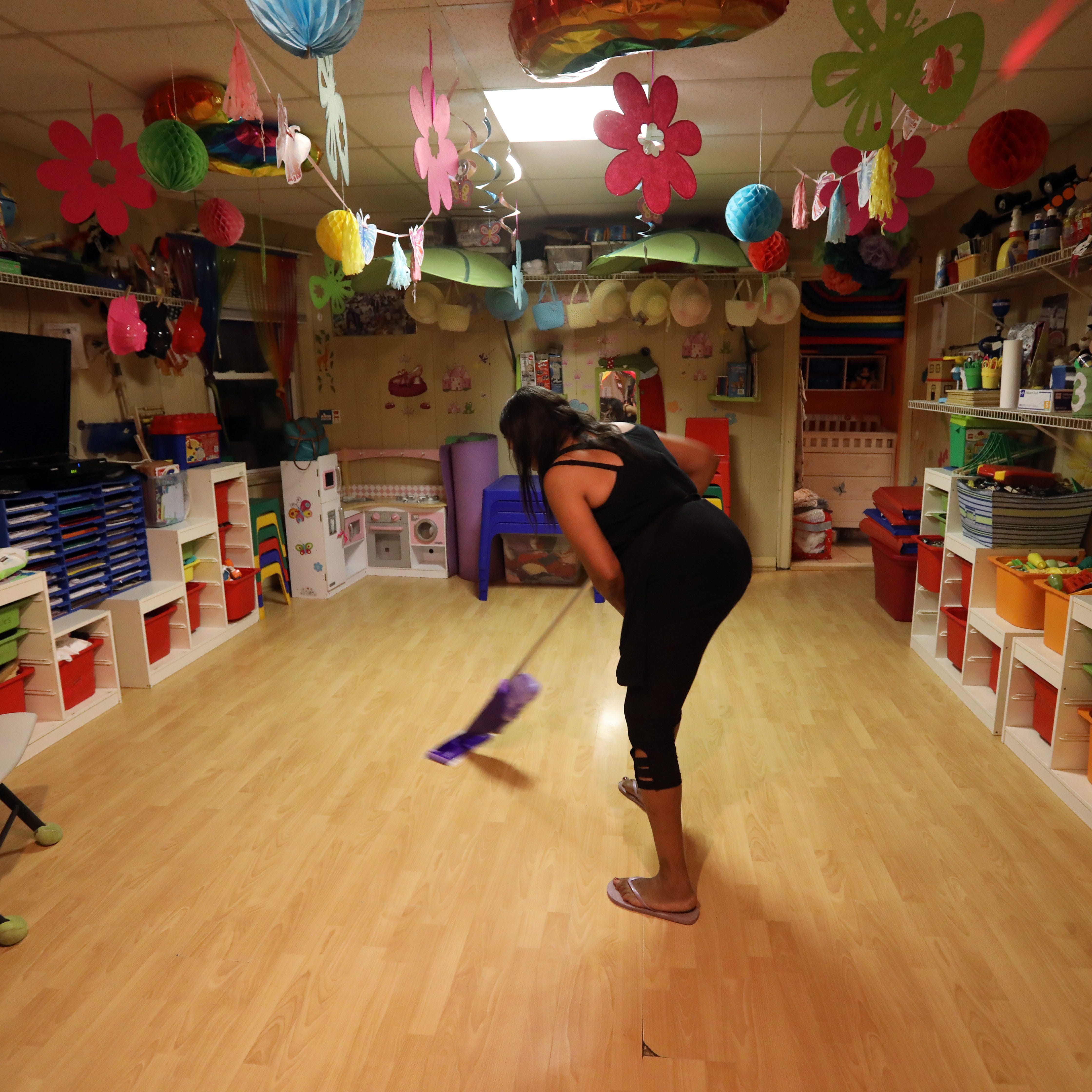 Deloris Hogan mops the floor after dinner at Dee's Tots Child Care in New Rochelle Aug. 15, 2019. Hogan and her husband Patrick run the day care. They also offer late and overnight care for children whose parents work late hours.