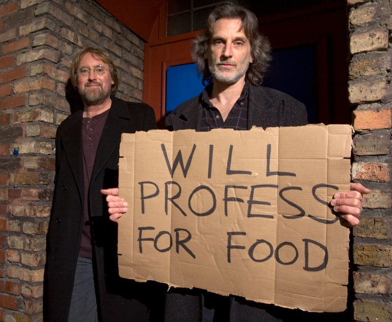 Andy Hollinden holds a sign that reads "Will profess for food" while standing next to Glenn Gass