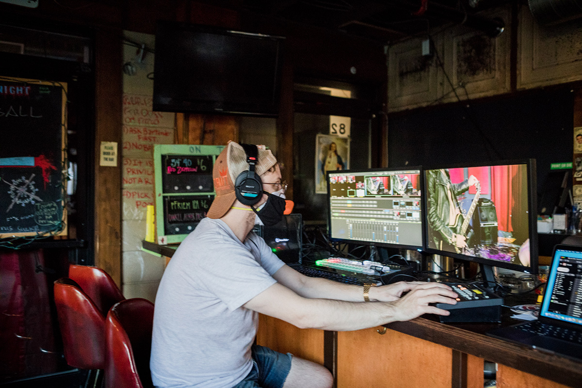 Chase Spross uses digital equipment, wearing headphones and a protective mask