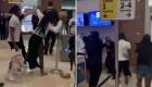 a group of people standing in a room: Three women arrested over violent Florida airport assault video