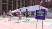 a group of people walking on a sidewalk: Students line up to get tested on the campus of New York University, a mandatory step to be able to go back to in person classes on September 2. A quarantine is also required.