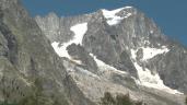 a rock on the side of a snow covered mountain: The Val Ferret in Italy remains on high alert and dozens of people have been evacuated over fears a huge chunk of a mountain glacier could break away.