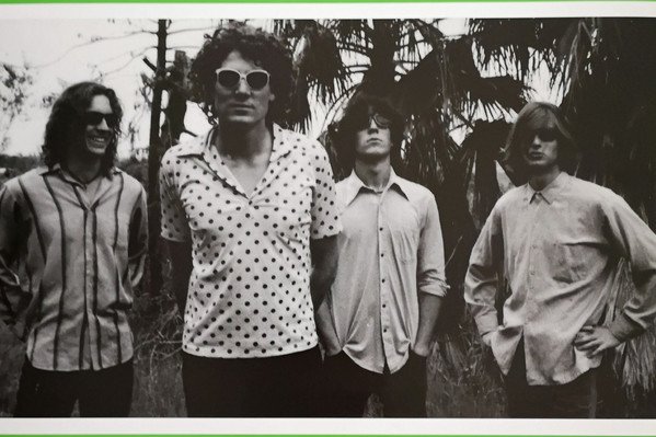 The Early Hours' album Greatest Hits Vol. 1 features a black and white photo of the band against a bright green background.